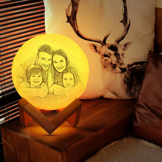 Personalized 3D moon lamp featuring etched picture of smiling couple, held in two hands.